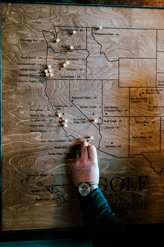 Man putting golf tees into a Centurion Map by Rota Golf